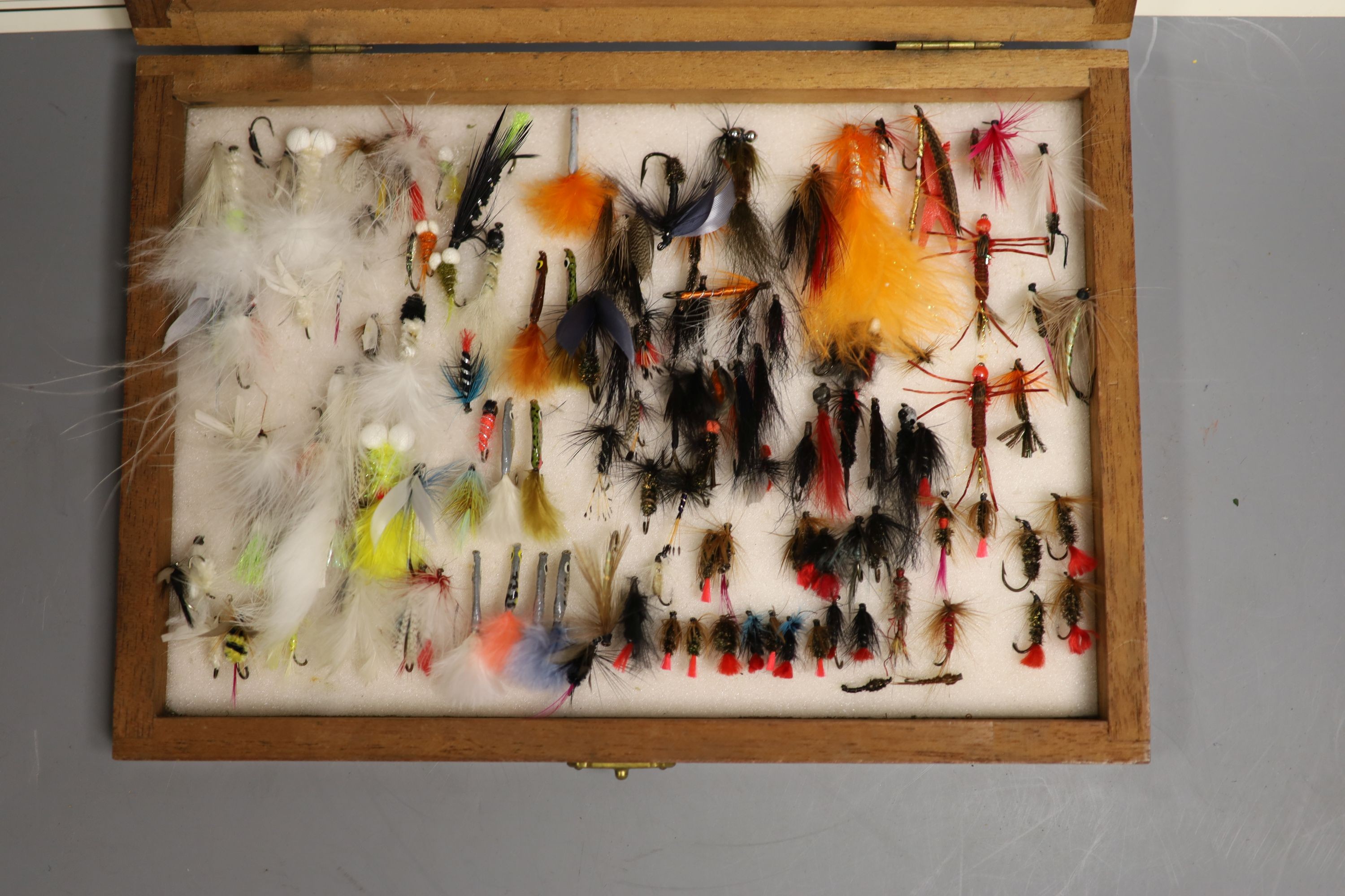 A cased collection of various fishing flies